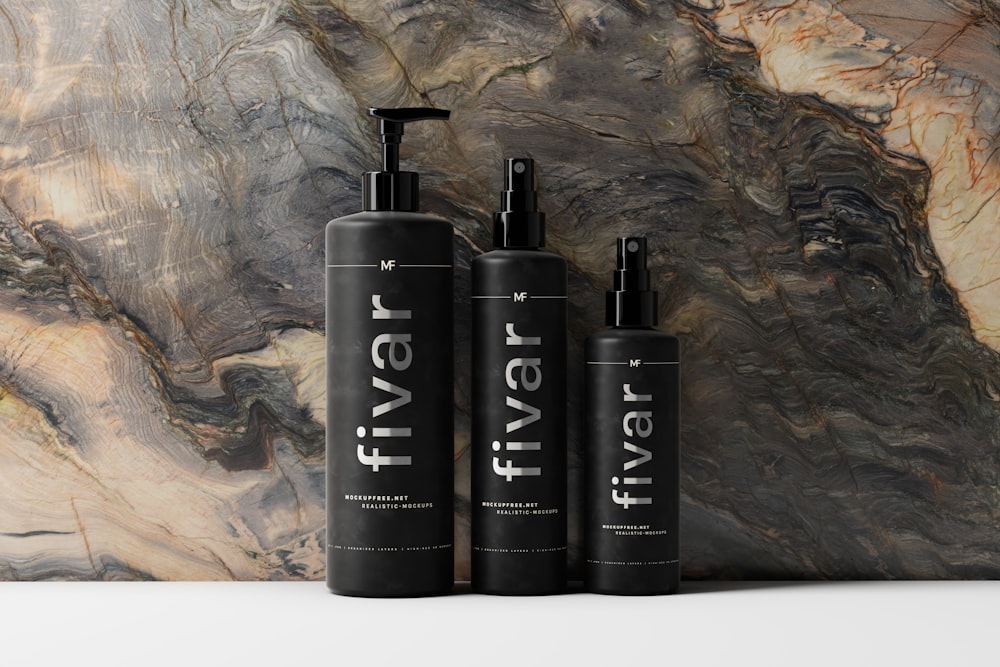 three bottles of hair products on a marble surface