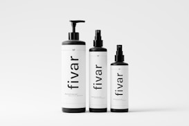 Three black and white bottles of various sizes are arranged in a line. Each bottle has a black cap, and the word 'fivar' is prominently displayed on their labels. The background is a plain light gray, giving the image a minimalist and clean appearance.
