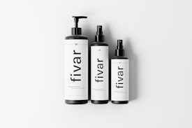 Three black and white bottles are displayed against a white background, featuring minimalistic labels with the word 'fivar' printed vertically. The bottles have matte black caps with varying dispensing mechanisms, such as pump and spray.