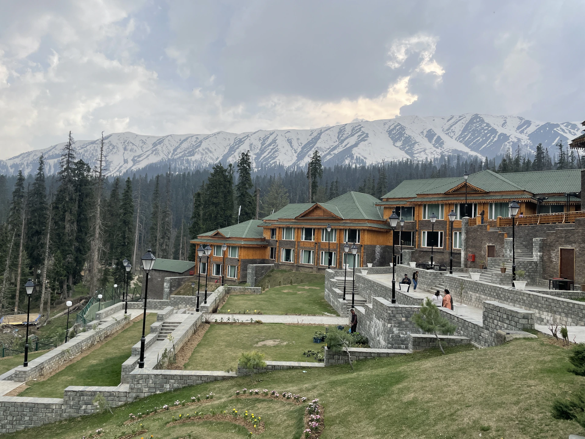 a group of buildings sitting on top of a lush green hillside