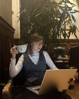 Elegant woman shopping online with a laptop and coffee at a cozy home setting