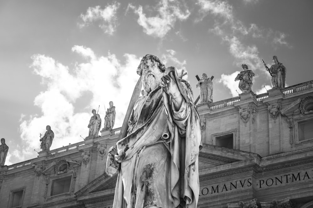 a black and white photo of a statue in front of a building