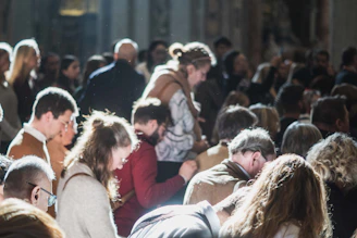 Crowd of shadowed figures in deep reflection, bathed in a faint white luminous light.