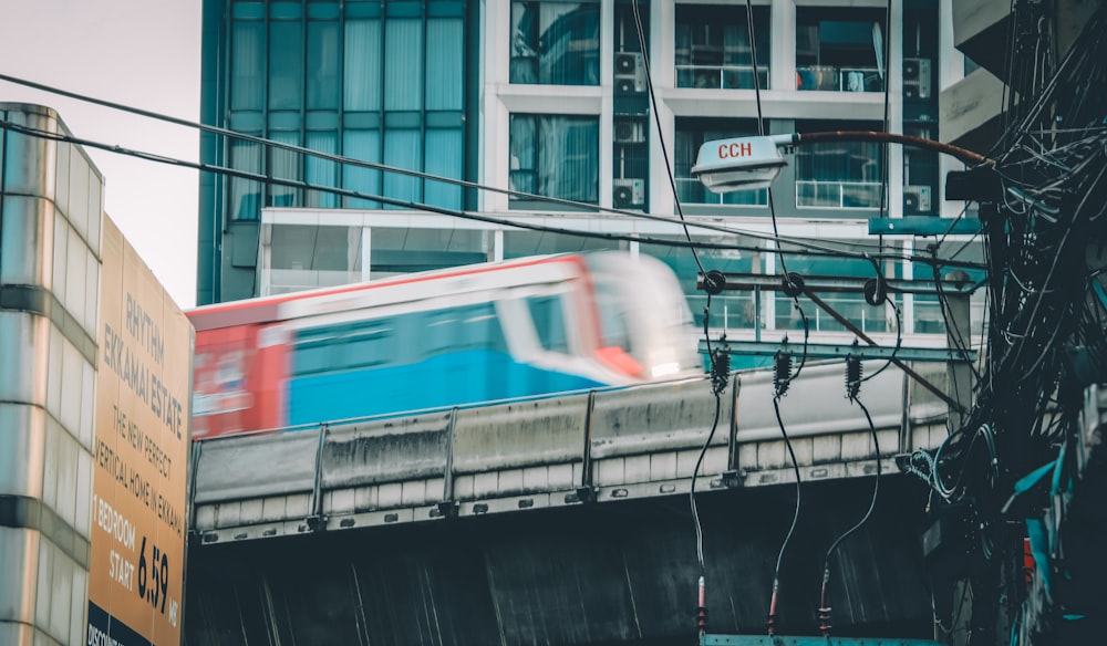 un treno che viaggia su un ponte accanto a un edificio alto