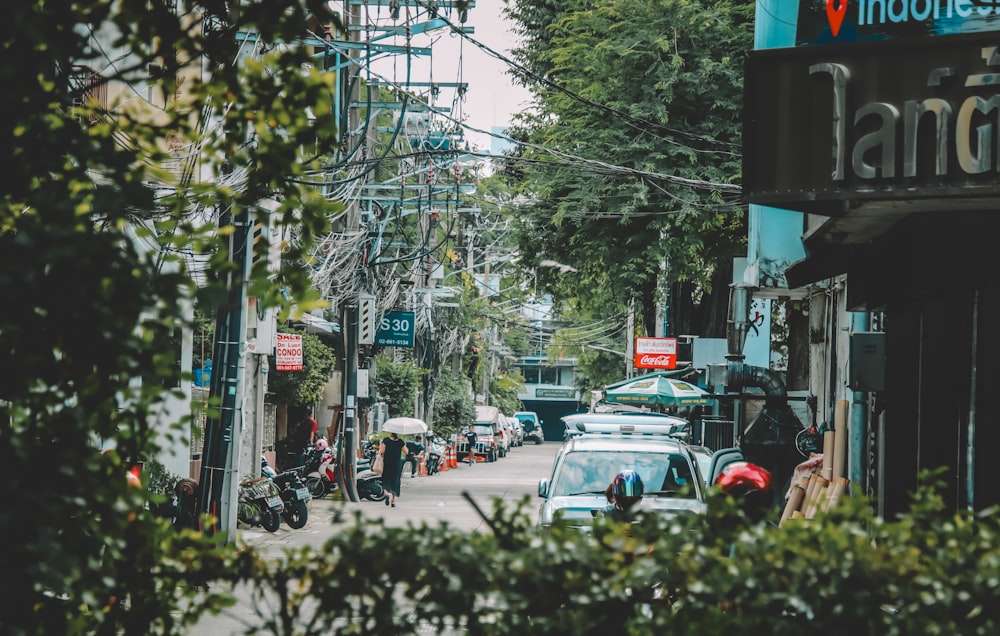 a busy city street with cars parked on the side of the road