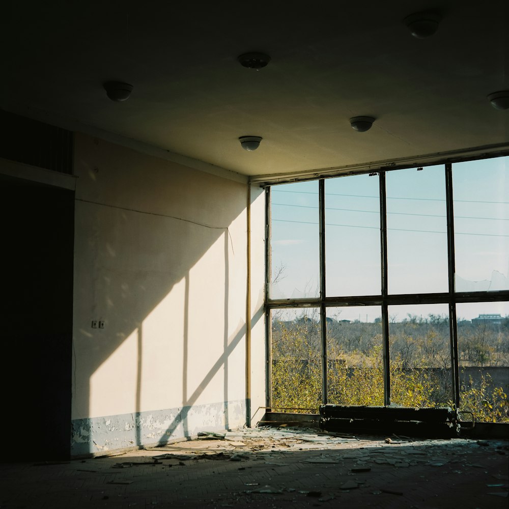 an empty room with large windows and a view of a forest