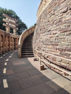 a stone wall with a spiral staircase next to it