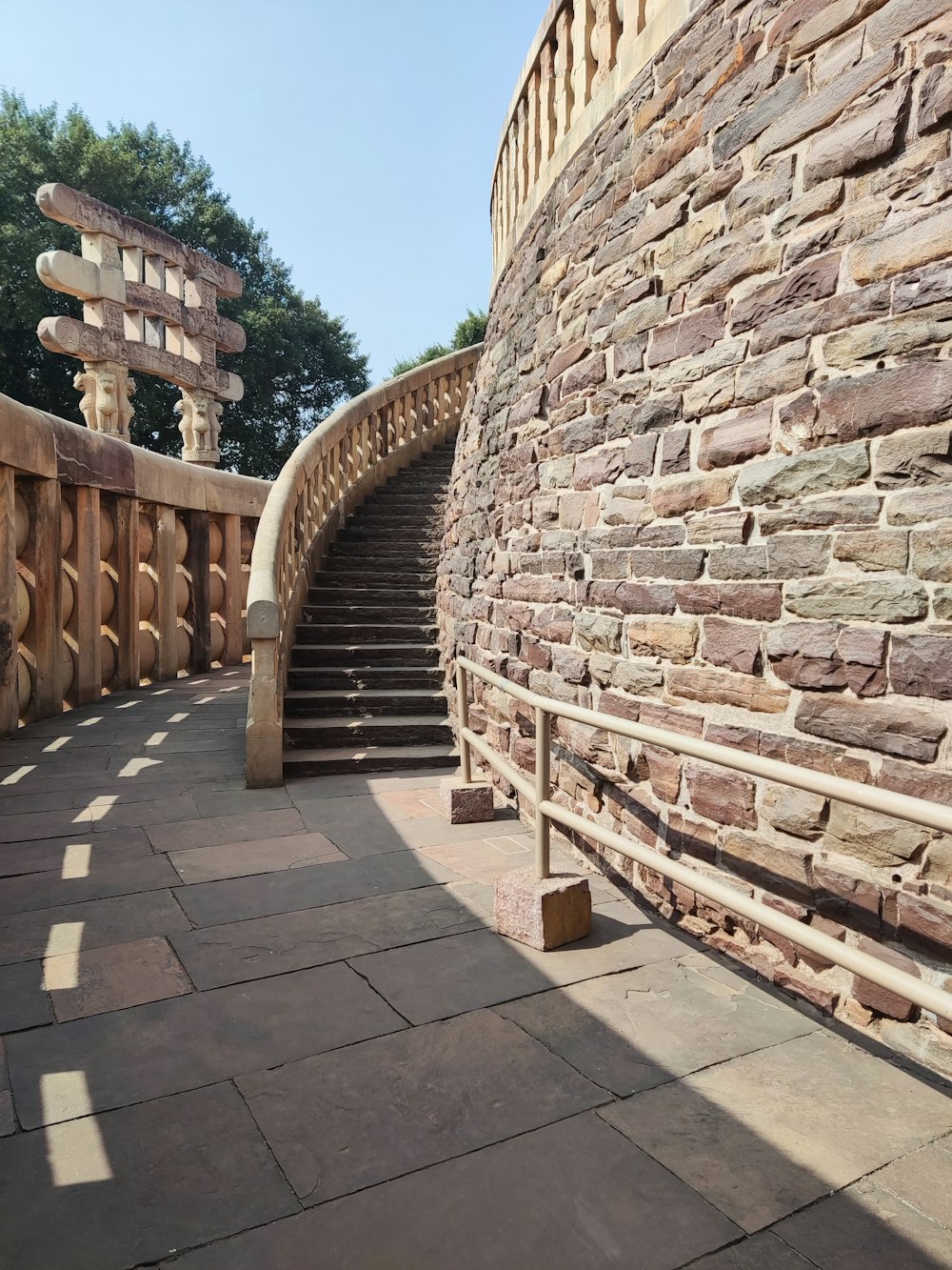 a stone wall with a spiral staircase next to it