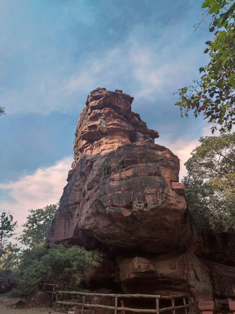 a large rock formation in the middle of a forest