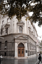 a large building with a wooden door on a city street