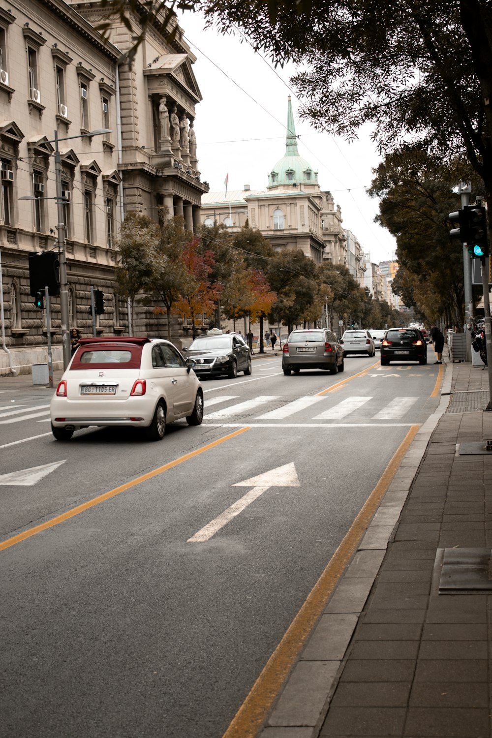 a city street filled with lots of traffic next to tall buildings