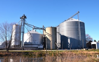 a large metal silo sitting next to a body of water