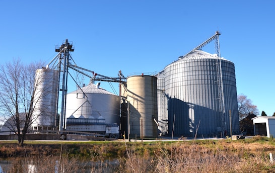 a large metal silo sitting next to a body of water