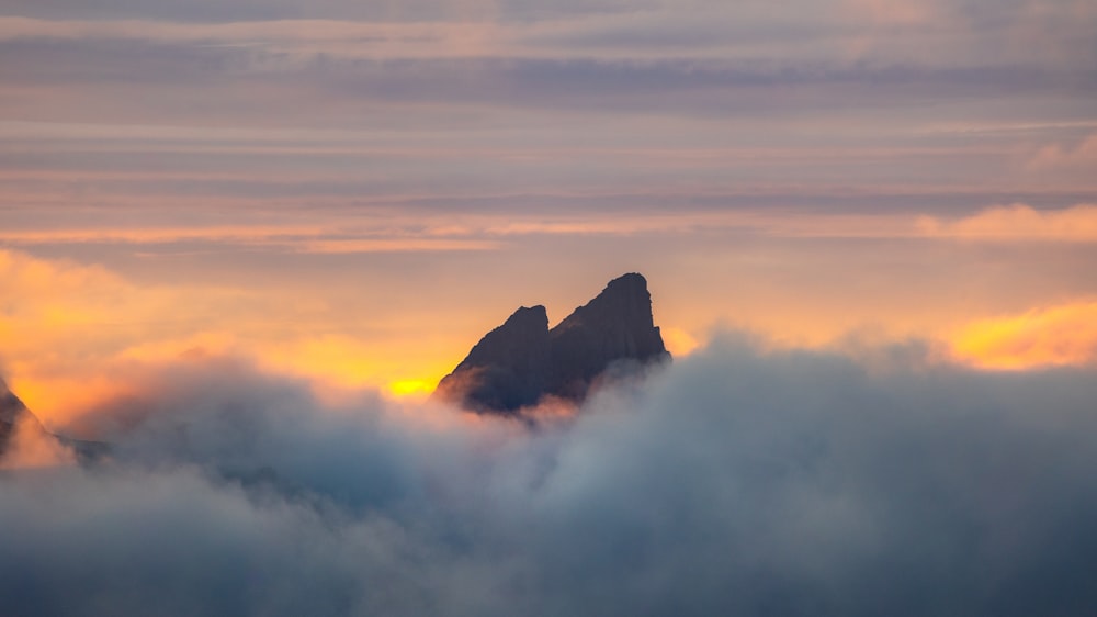 a mountain in the distance surrounded by clouds