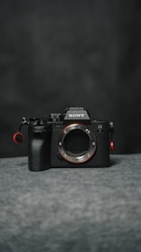 A luxurious mirrorless camera with a compact design displayed against a dark velvet background.