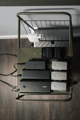 A vibrant display of mobile chargers in bright colors arranged neatly on a cozy wooden shelf.