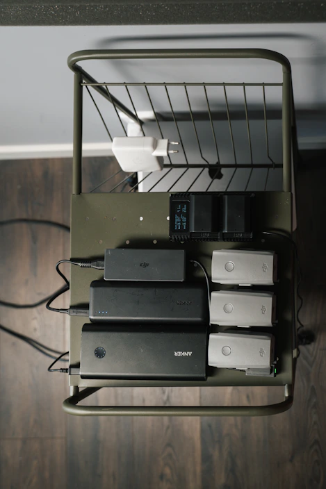 A vibrant display of mobile chargers in bright colors arranged neatly on a cozy wooden shelf.