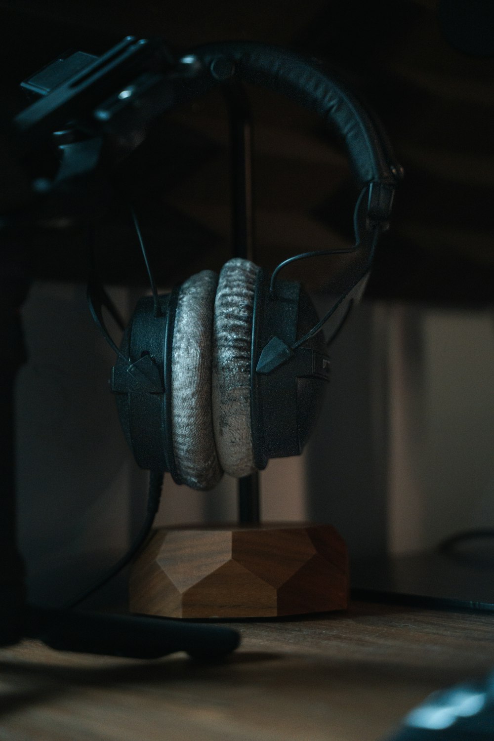 a pair of headphones sitting on top of a wooden stand