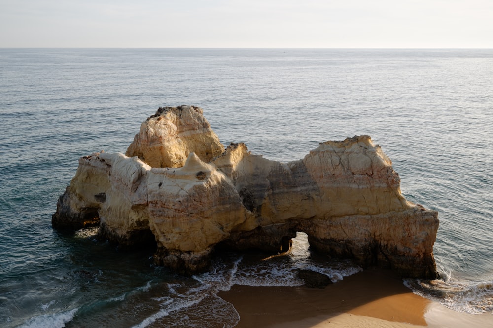 a rocky outcropping on a beach near the ocean