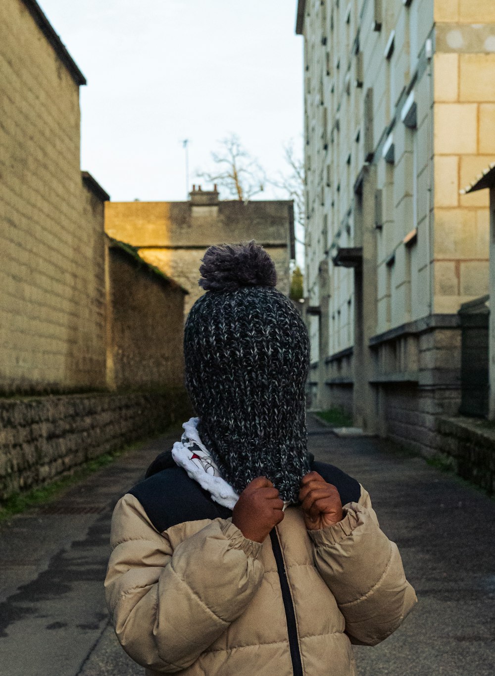 a person walking down a street with a hat on their head