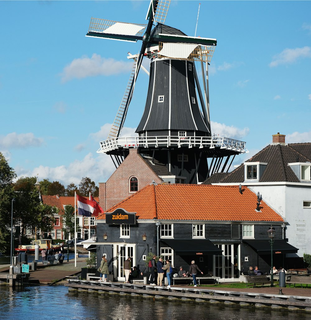 a windmill sitting on top of a pier next to a river
