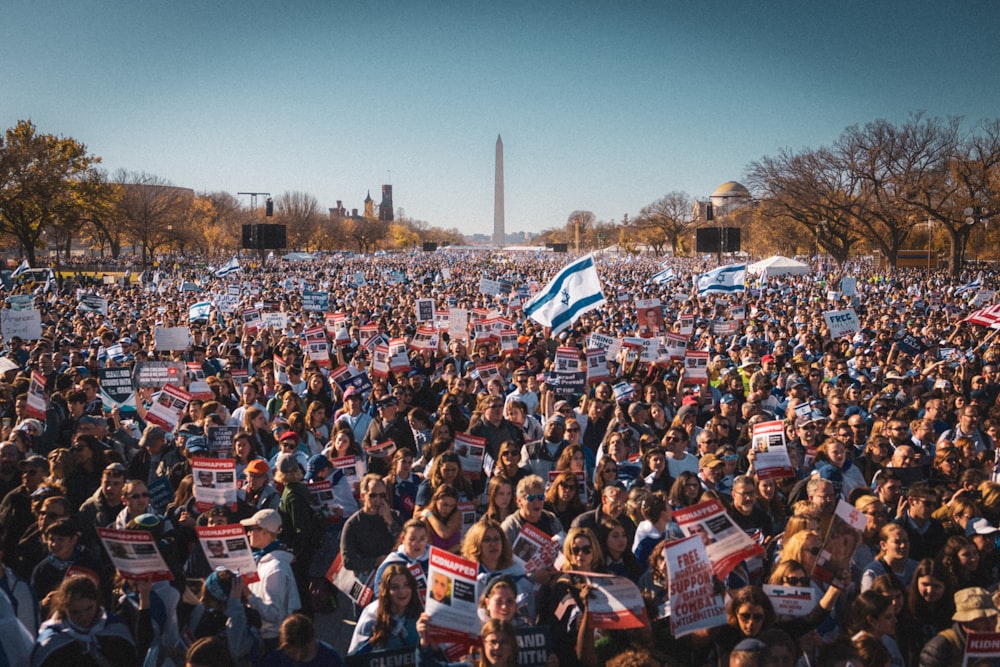 a large crowd of people holding signs and flags