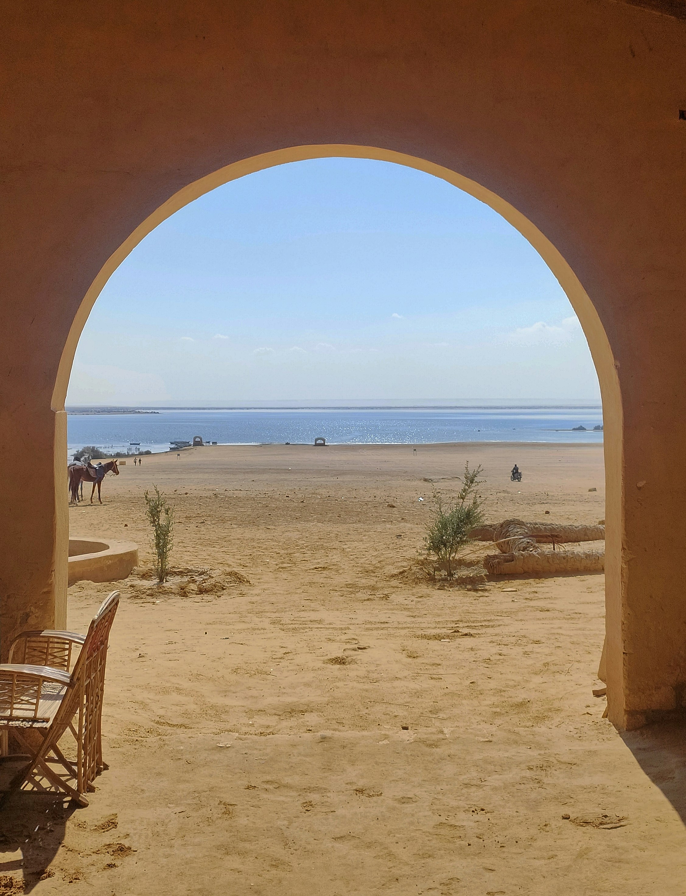 Blick auf einen Strand durch einen Torbogen