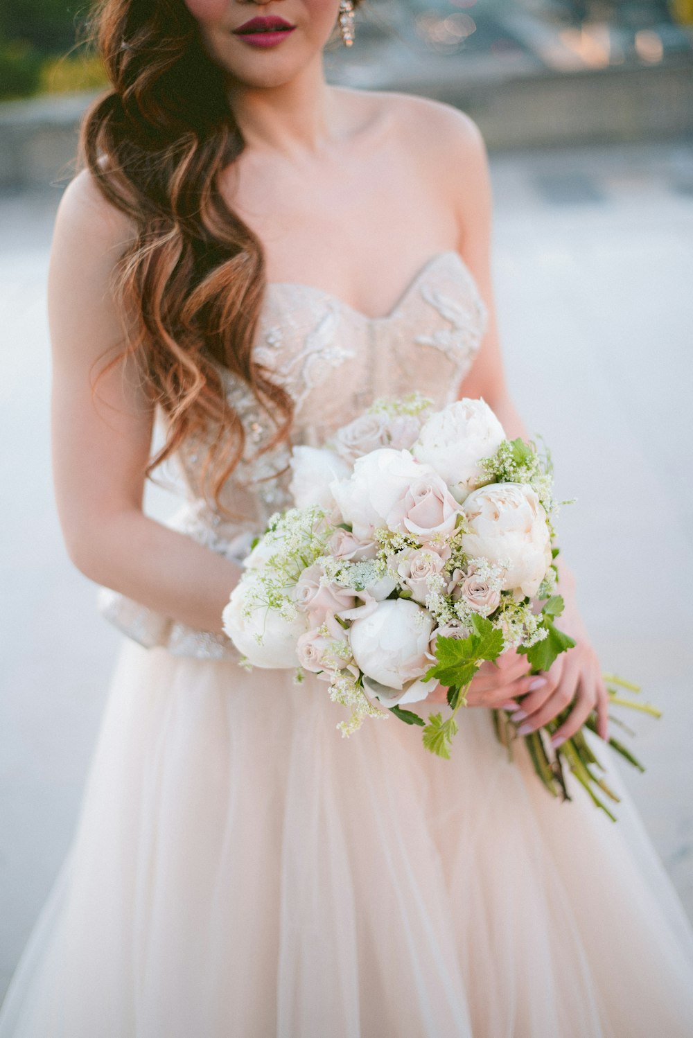 a woman in a wedding dress holding a bouquet of flowers