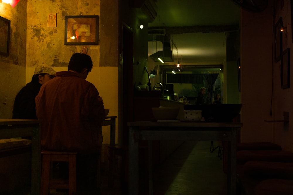 a group of people sitting at a table in a dark room