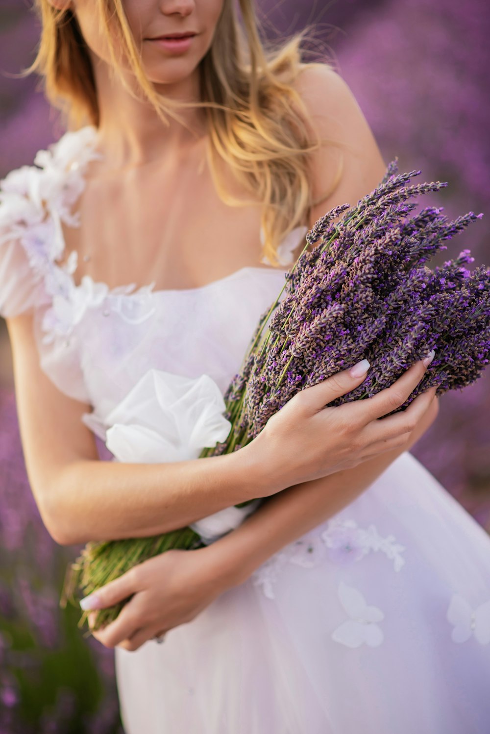 a woman in a white dress holding a bouquet of flowers