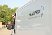Founder Nayan Chatwani shaking hands with a satisfied customer beside a delivery truck.