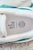 An image of a sneaker with a visible insole featuring the text 'END PLASTIC WASTE' alongside a globe symbol. The sneaker's interior includes shades of white and accents of teal. It is placed on a textured carpet surface.