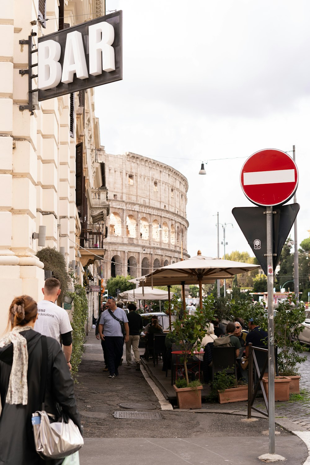 un gruppo di persone che camminano lungo una strada accanto a un edificio