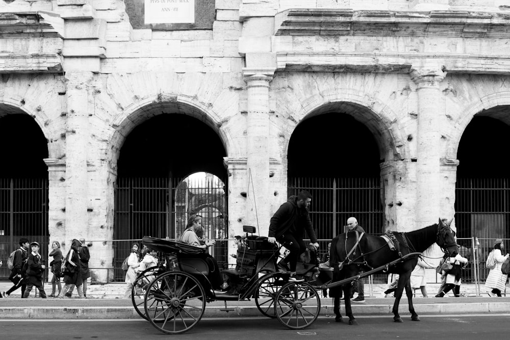 a black and white photo of a horse drawn carriage