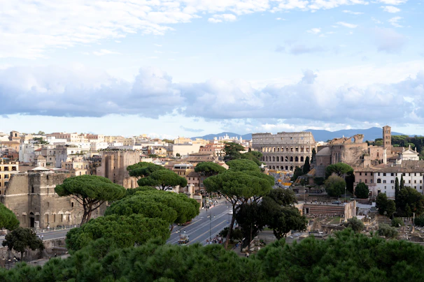 A panoramic view of the ancient city of Rome, featuring the Colosseum bathed in golden afternoon light.