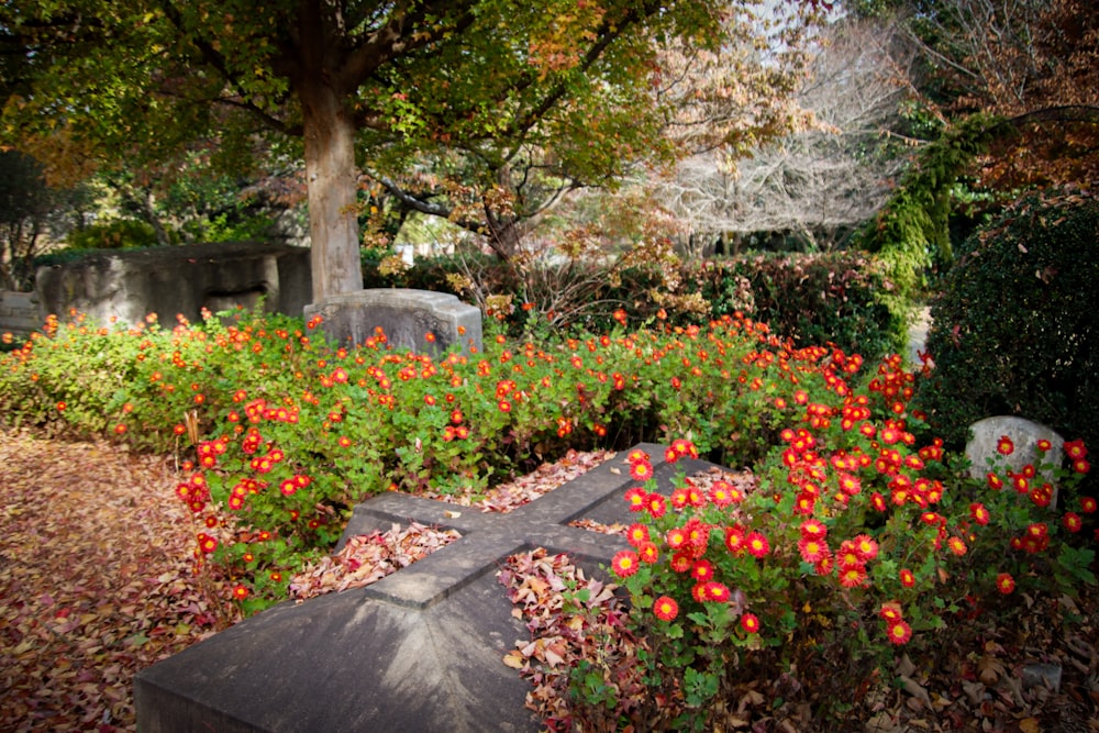 a grave surrounded by flowers and trees