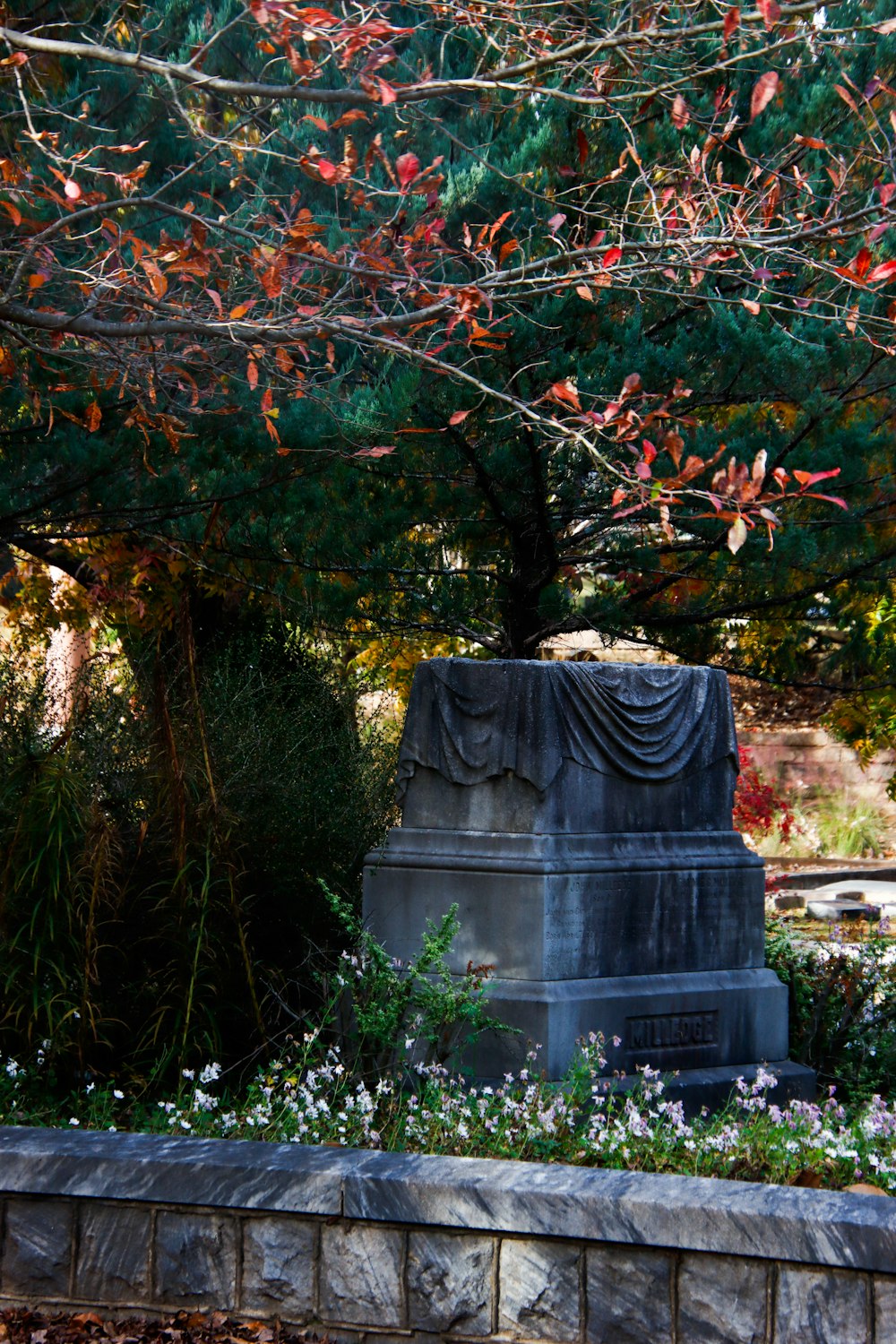 a monument in the middle of a park surrounded by trees