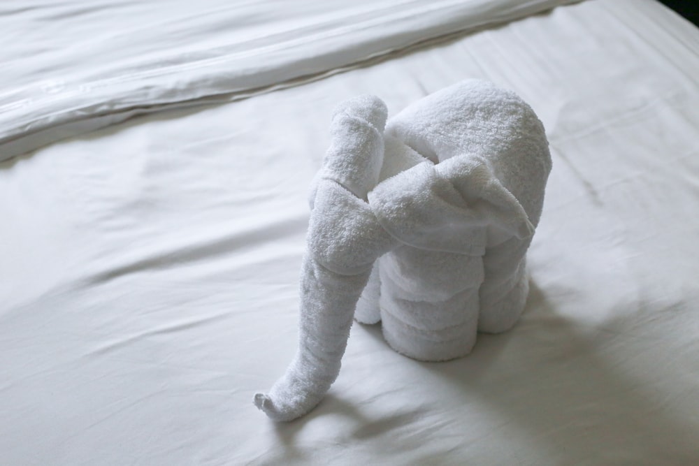 a white towel shaped like an elephant on a bed