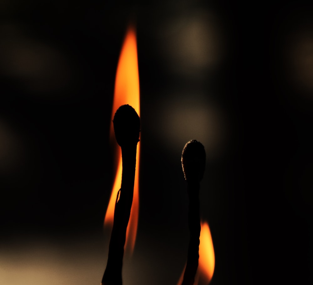a close up of a pair of matchsticks on fire