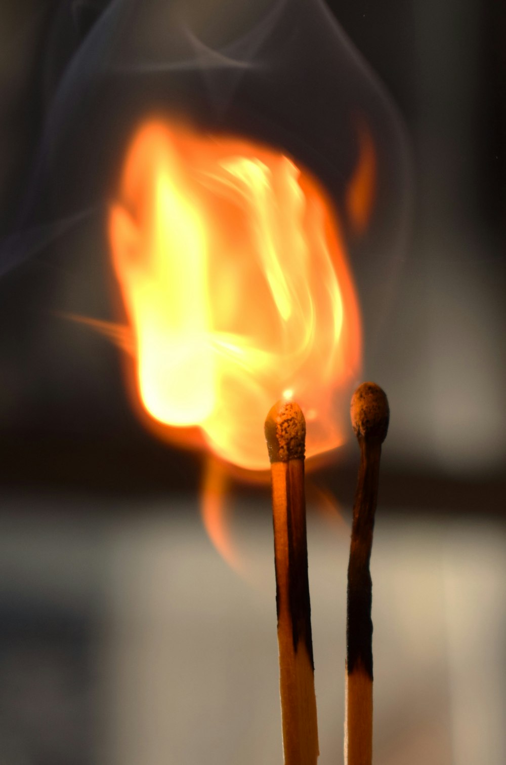 a close up of two matches with a fire in the background