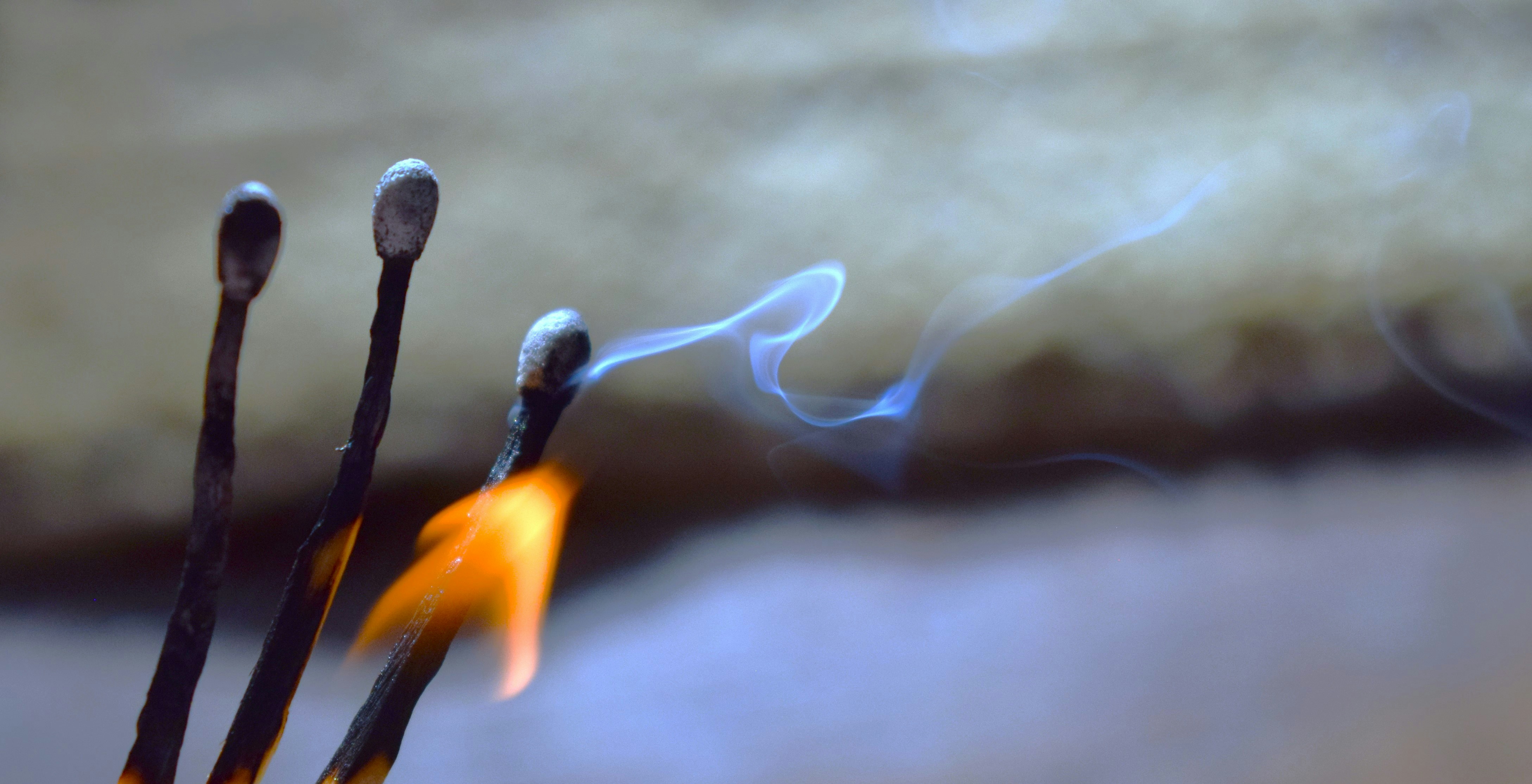 Un primer plano de un montón de palos con fuego de fondo