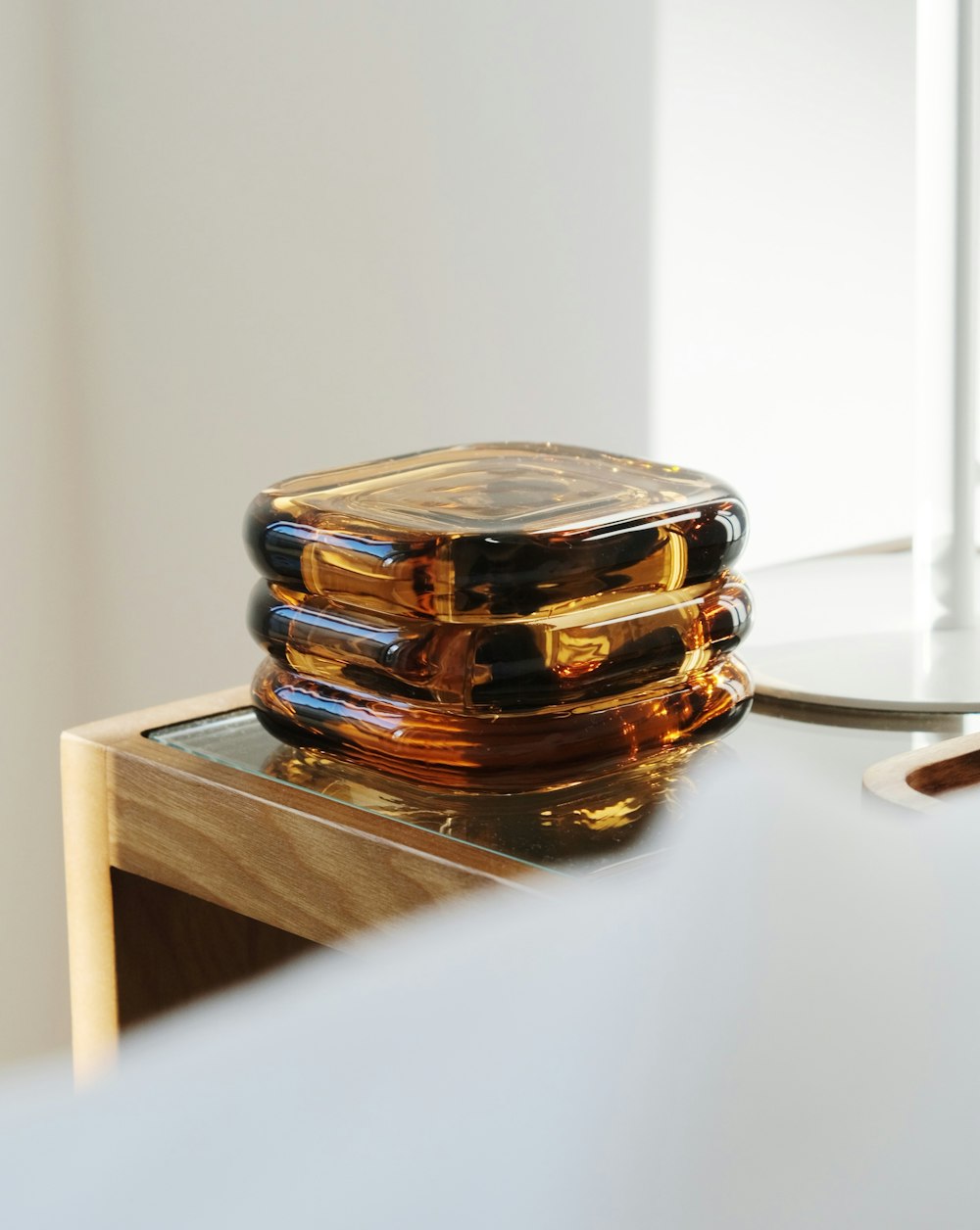 a stack of glass plates sitting on top of a wooden table