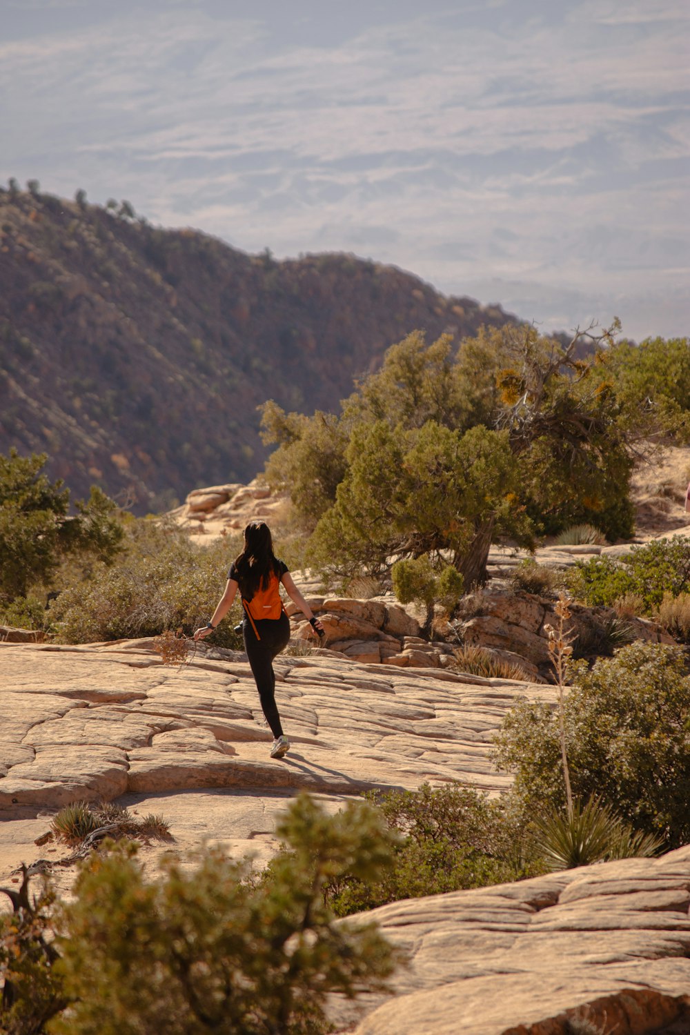 a woman running on a trail in the mountains