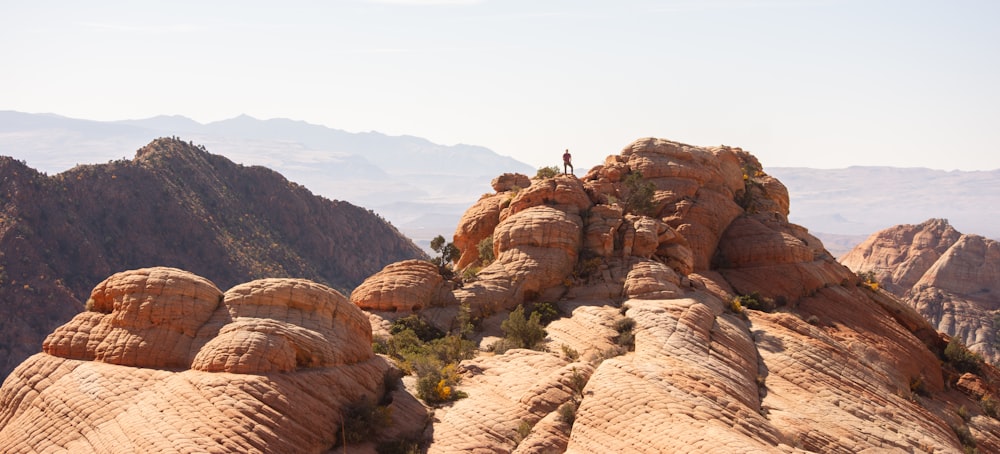 a person standing on top of a large rock formation