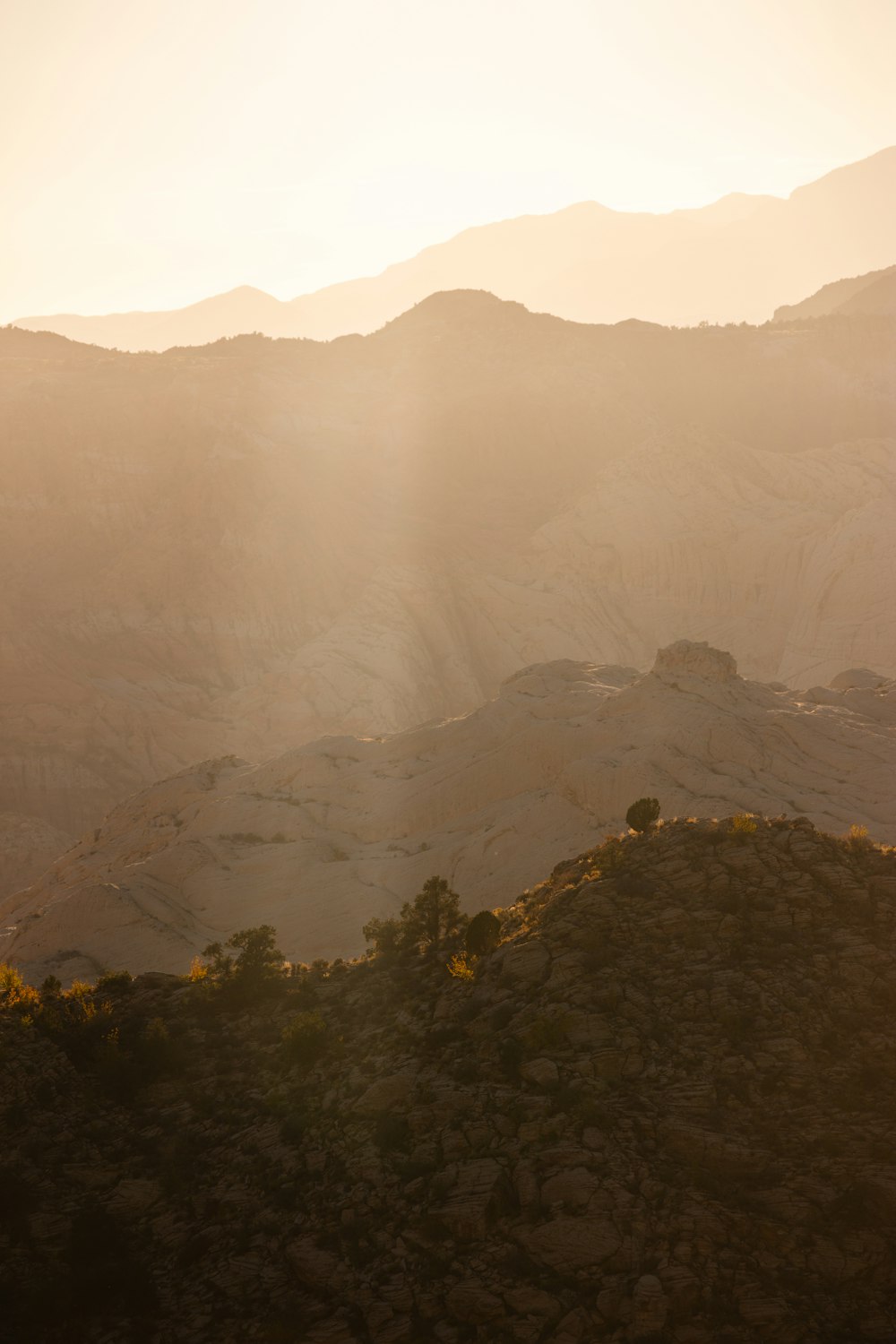 the sun is shining over the mountains and hills