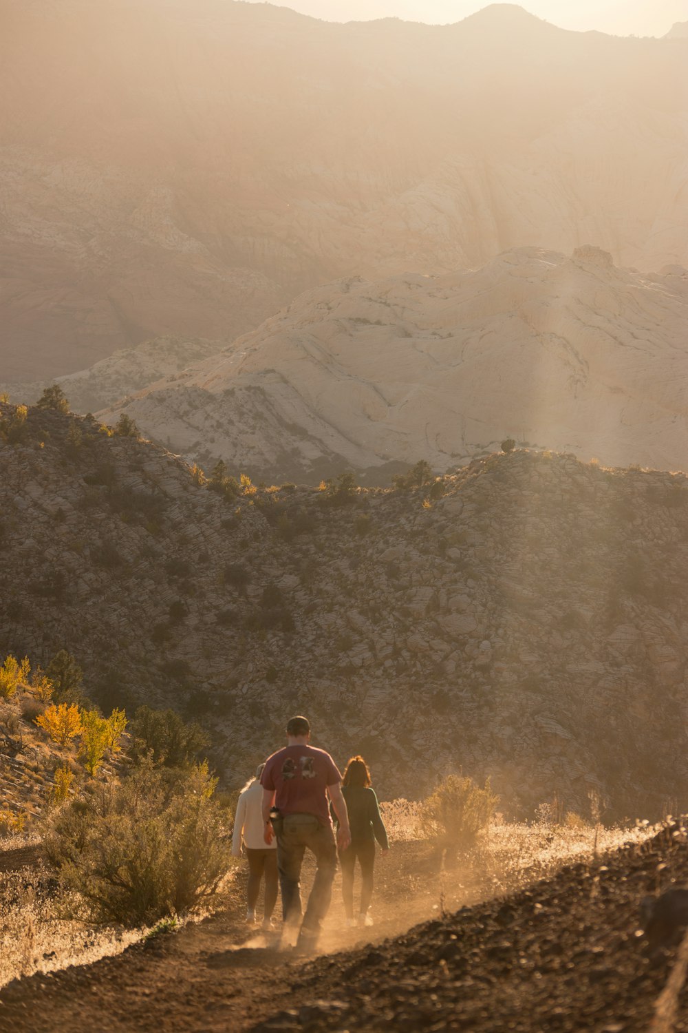 a group of people walking down a dirt road