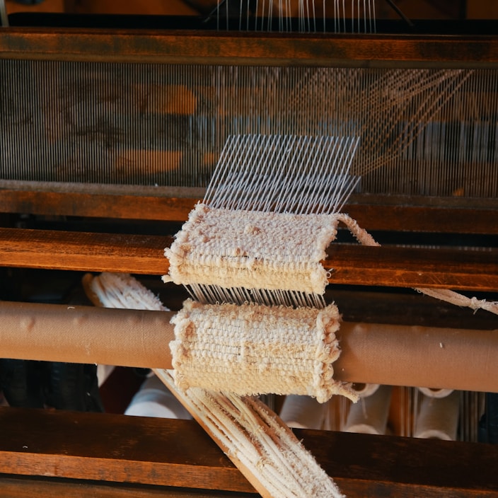 Close-up of a rich, handwoven silk saree draped gracefully on a wooden loom.