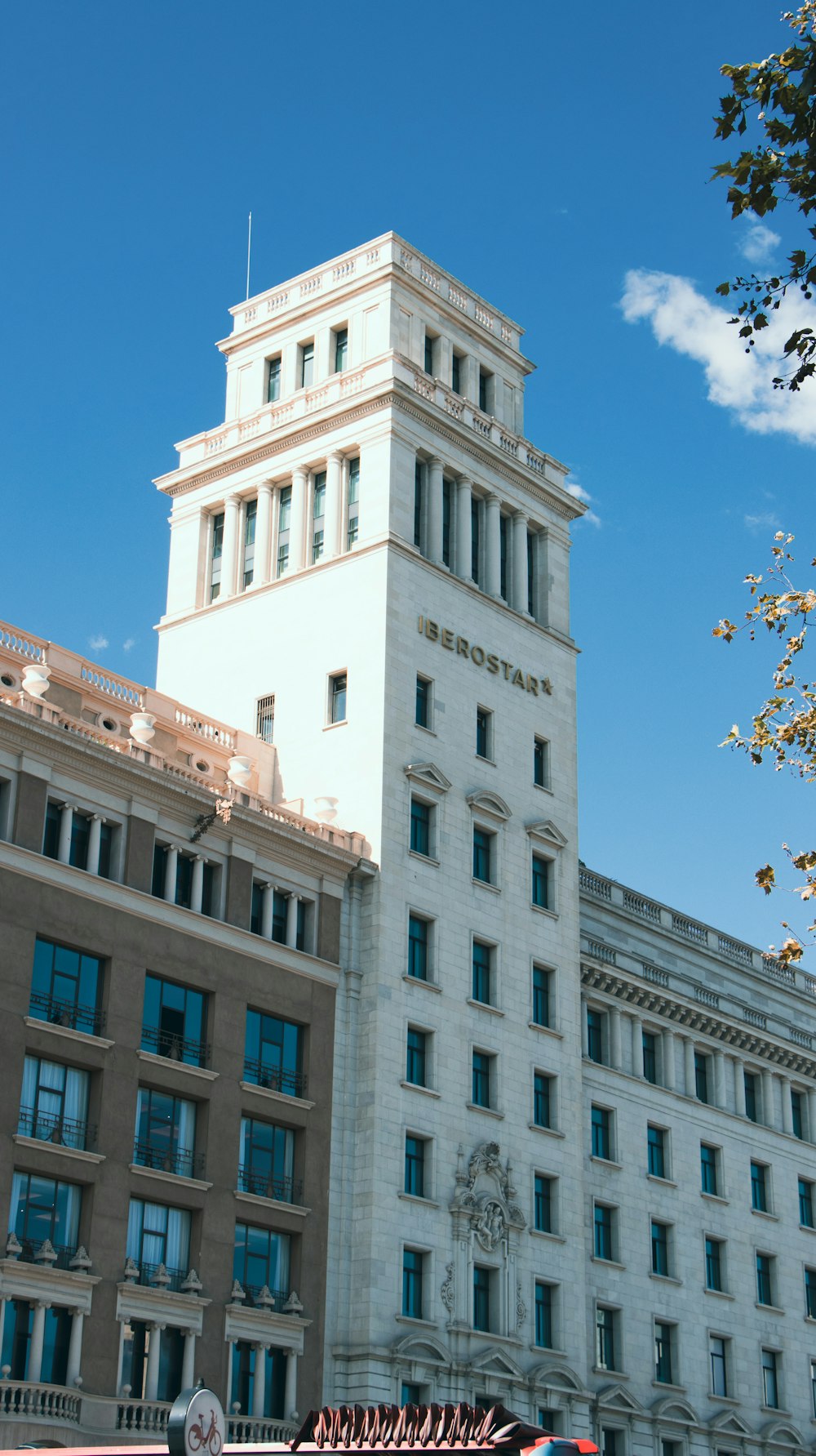 a tall white building with a clock on the top of it