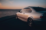 Elegant silver coupe reflecting city lights during twilight