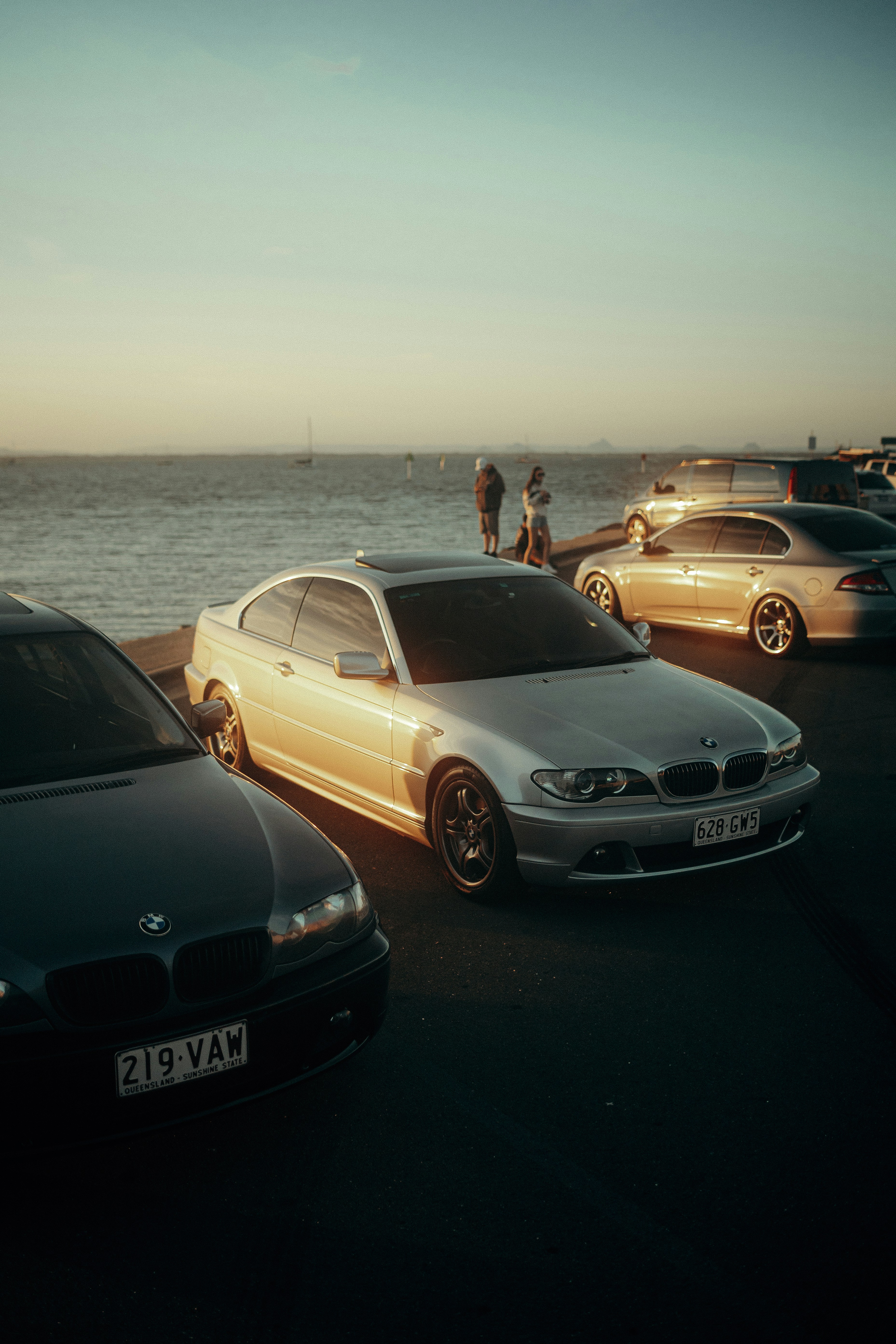 un groupe de voitures garées les unes à côté des autres près de l’océan